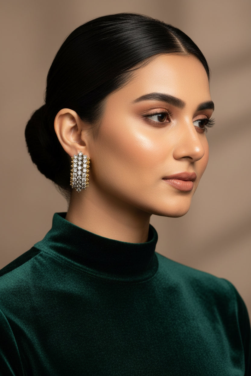 Gold and silver earrings in a white box with Metcos branding.
