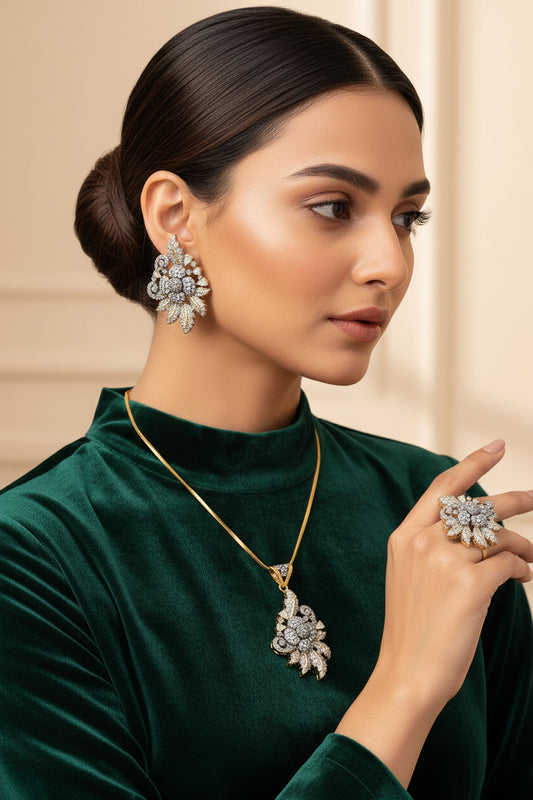 A set of gold-plated jewelry featuring a floral design, including a pendant, earrings, and a ring, adorned with zirconia stones.
