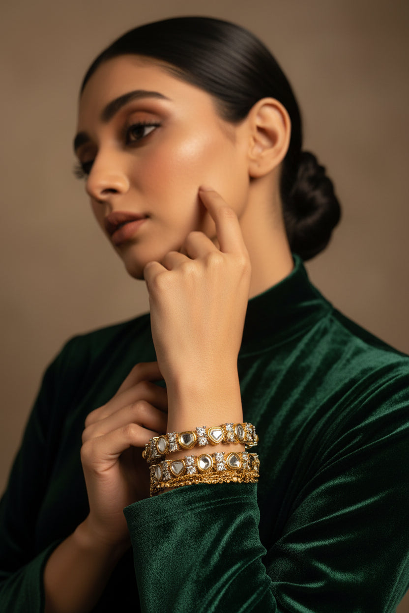 Pair of 24K gold plated kundani bangles set with flat kundan-style stones in a beaded gold frame, worn on the wrist
