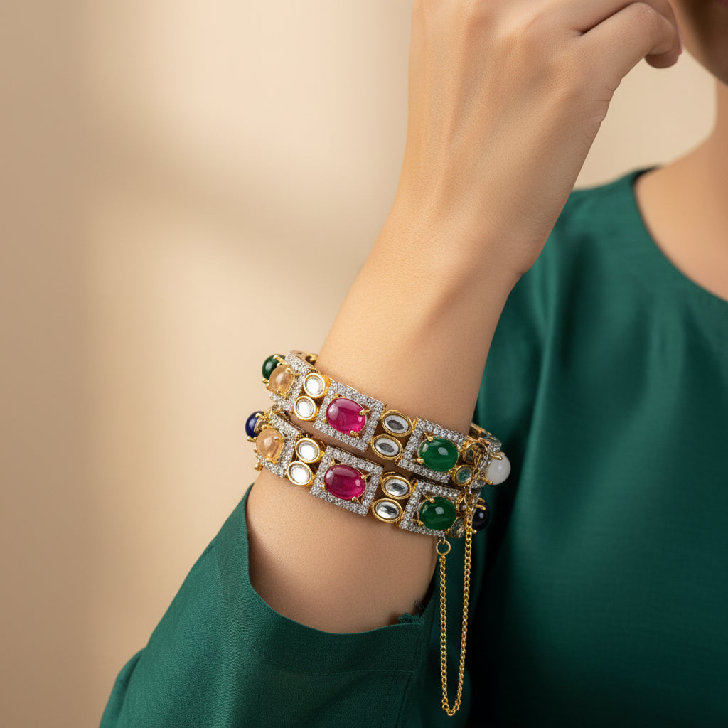 Two 24k gold plated, diamond-cut bangle bracelets with a variety of colorful beads and zircon stones, displayed on a rocky surface.