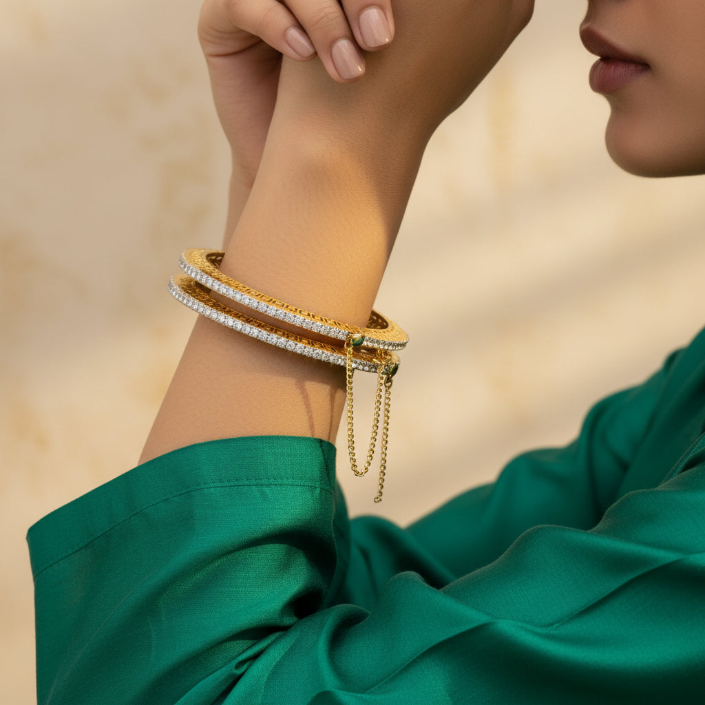 A gold-plated, diamond-cut bangle with a floral pattern and zircon stones, displayed against a textured background.